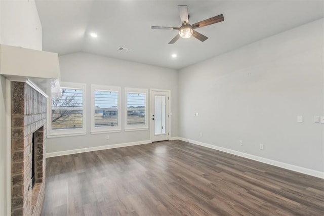 unfurnished living room featuring lofted ceiling, a brick fireplace, dark wood-type flooring, and ceiling fan