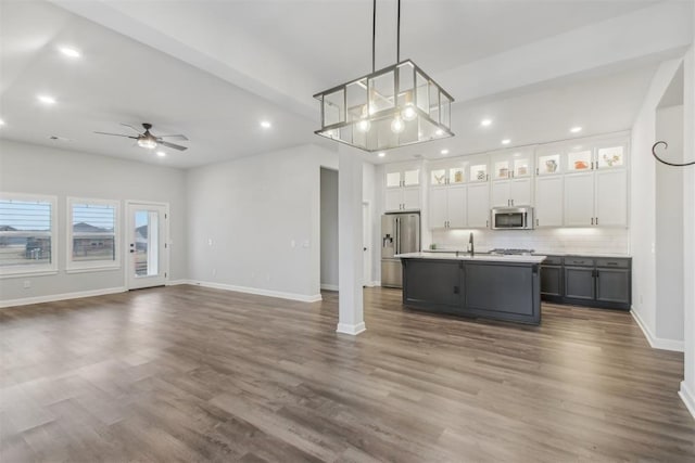 kitchen with gray cabinets, white cabinetry, hanging light fixtures, stainless steel appliances, and a center island with sink