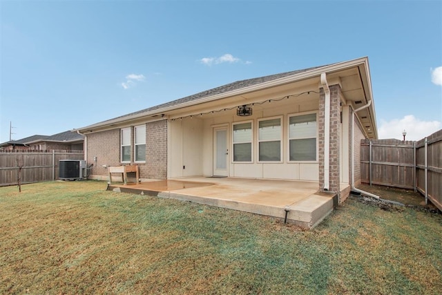 rear view of property featuring central AC unit, a lawn, and a patio