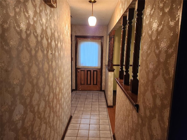 doorway featuring light tile patterned floors and a textured ceiling