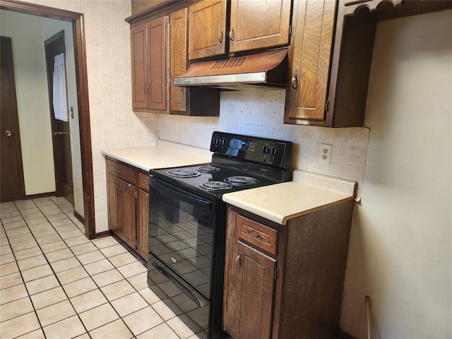 kitchen featuring decorative backsplash, light tile patterned floors, and black range with electric cooktop