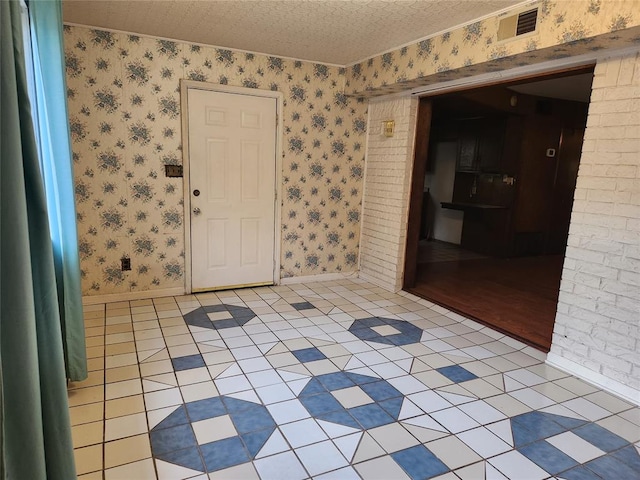 tiled entryway with a textured ceiling