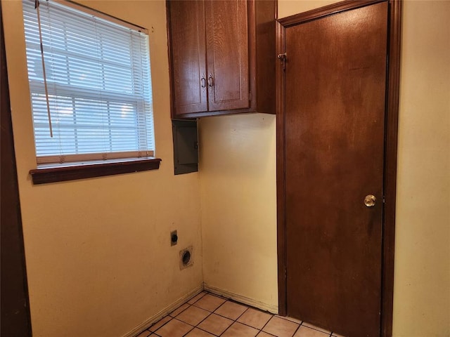 washroom with electric panel, light tile patterned flooring, cabinets, and hookup for an electric dryer