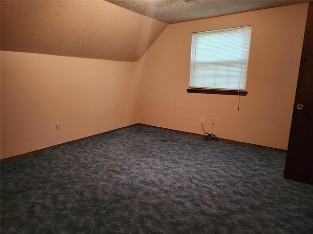 bonus room featuring dark colored carpet, a textured ceiling, and vaulted ceiling