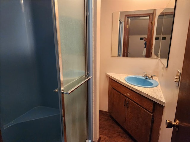 bathroom featuring hardwood / wood-style flooring, vanity, and a shower with shower door