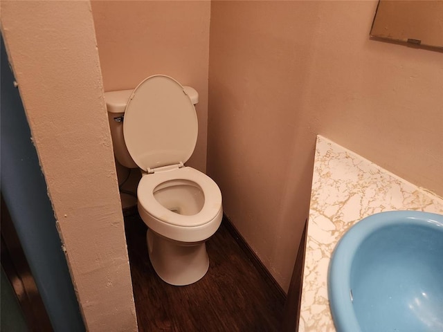 bathroom featuring wood-type flooring, toilet, and sink