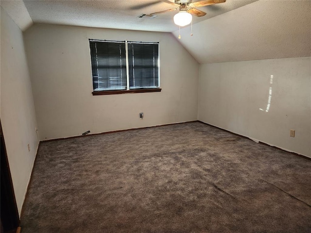 additional living space with ceiling fan, dark carpet, a textured ceiling, and vaulted ceiling