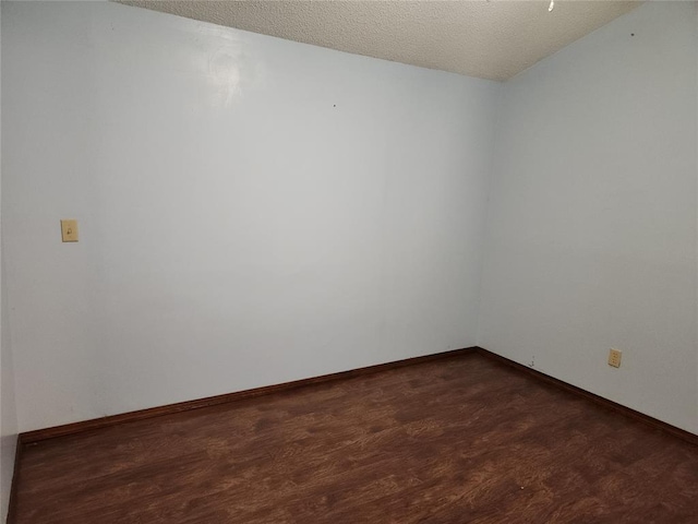 empty room featuring dark hardwood / wood-style flooring and a textured ceiling