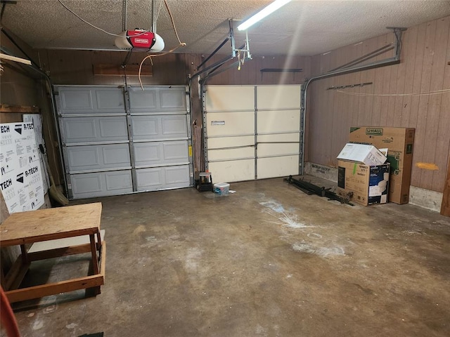 garage with a garage door opener and wooden walls