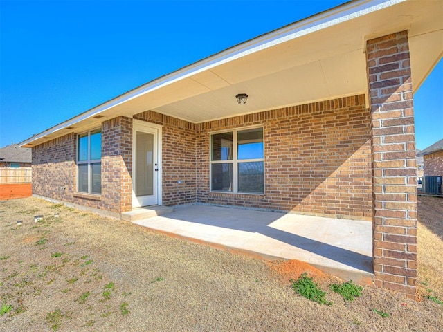 doorway to property with cooling unit and a patio area