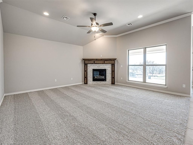 unfurnished living room featuring carpet flooring, ornamental molding, a stone fireplace, and lofted ceiling