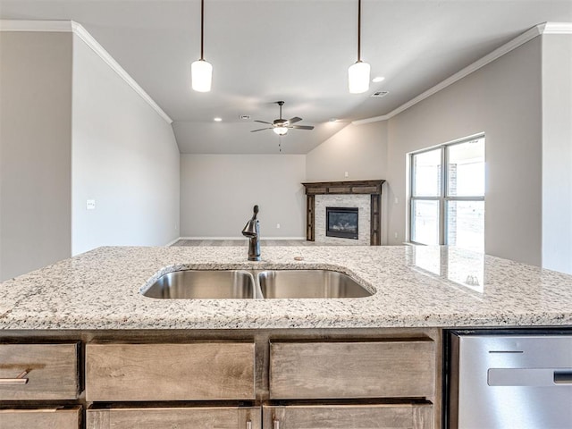 kitchen with crown molding, light stone countertops, and sink