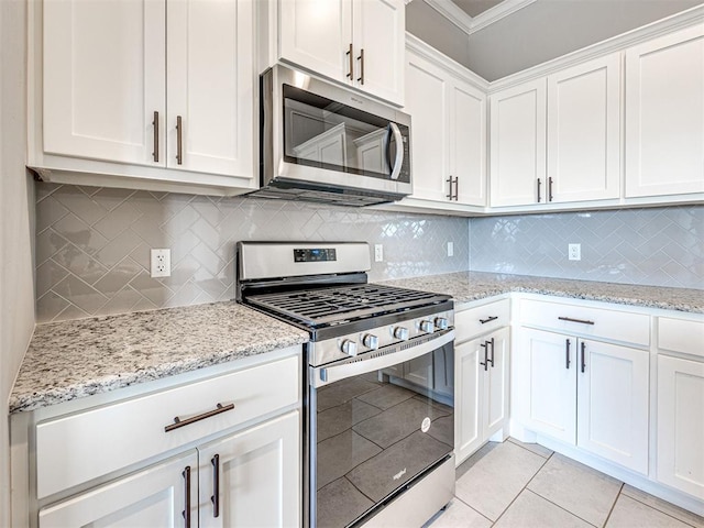 kitchen featuring decorative backsplash, white cabinetry, stainless steel appliances, and ornamental molding