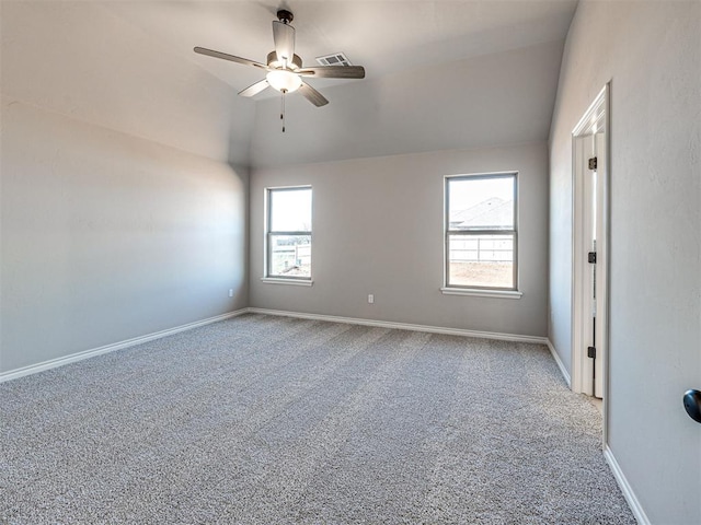 carpeted spare room featuring vaulted ceiling and ceiling fan