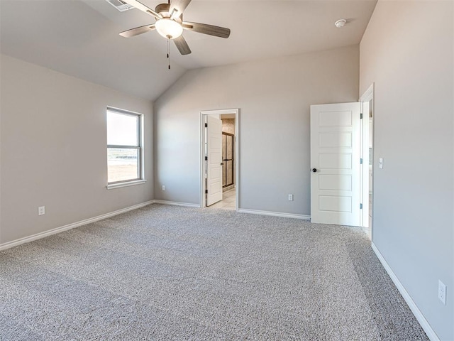 carpeted spare room featuring ceiling fan and vaulted ceiling