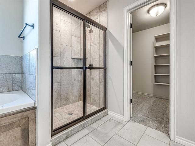 bathroom featuring tile patterned flooring and shower with separate bathtub