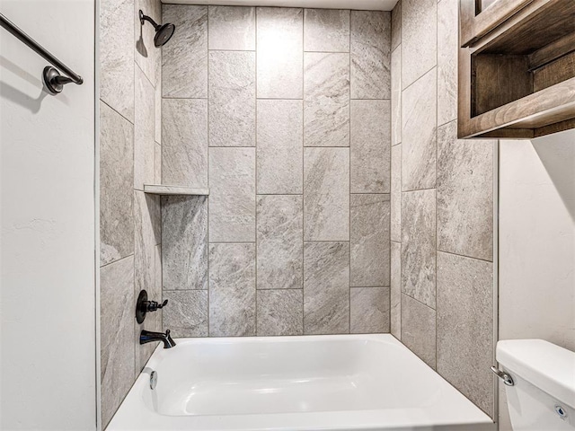 bathroom with tiled shower / bath combo and toilet