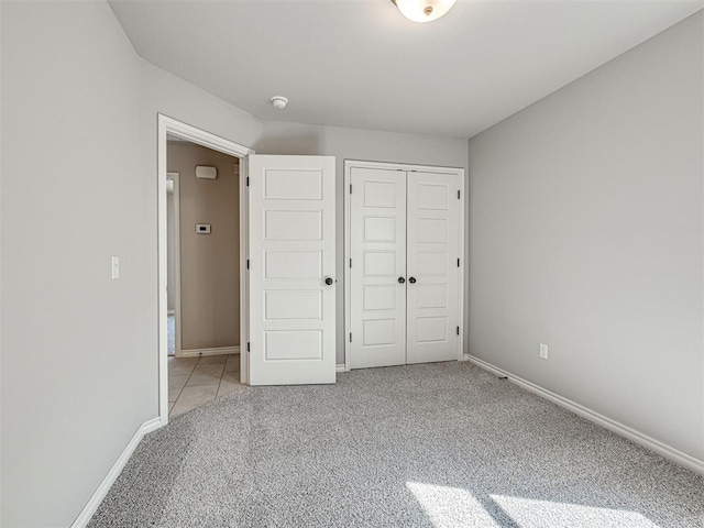 unfurnished bedroom with a closet and light colored carpet