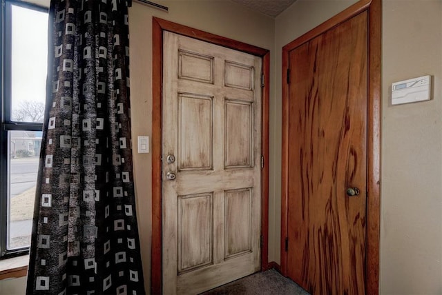 doorway to outside featuring a textured ceiling