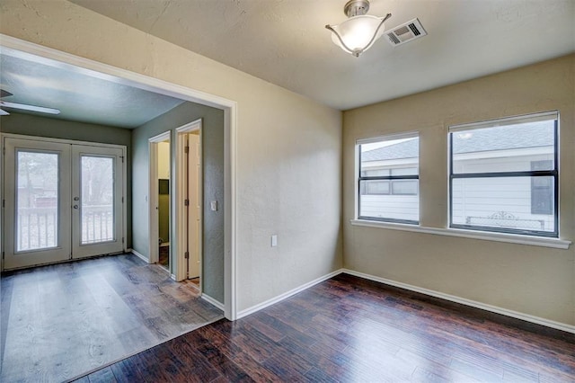 unfurnished room with dark hardwood / wood-style floors, ceiling fan, and french doors