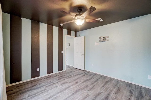 empty room with ceiling fan and light hardwood / wood-style floors