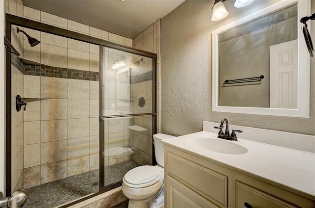 bathroom with vanity, toilet, and a shower with shower door