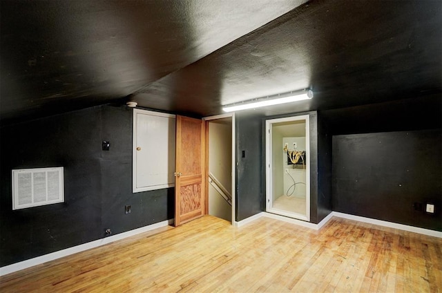 bonus room with light hardwood / wood-style floors and vaulted ceiling