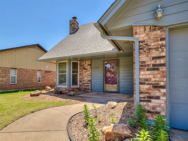 6404 Westway, Oklahoma City, OK 73142 - entrance to property featuring brick siding, roof with shingles, a chimney, and a yard
