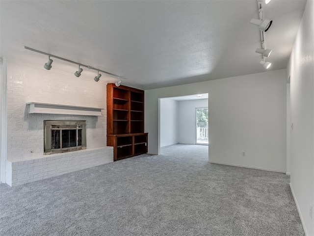 6404 Westway, Oklahoma City, OK 73142 - unfurnished living room featuring track lighting, carpet floors, and a brick fireplace