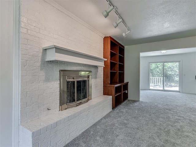 6404 Westway, Oklahoma City, OK 73142 - unfurnished living room featuring carpet floors, rail lighting, and a fireplace