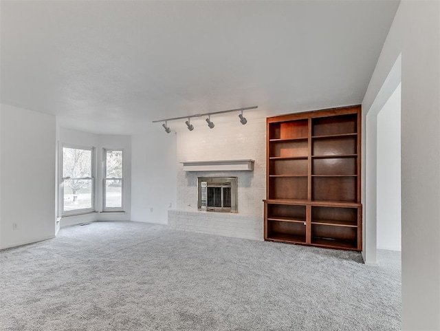 6404 Westway, Oklahoma City, OK 73142 - unfurnished living room featuring track lighting, a fireplace, and carpet flooring