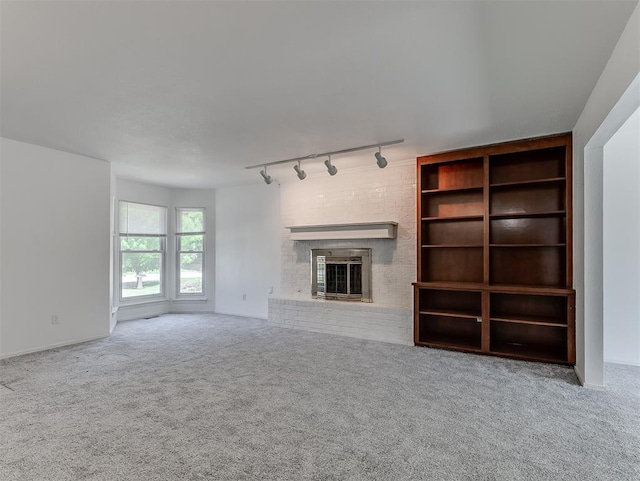 6404 Westway, Oklahoma City, OK 73142 - unfurnished living room with rail lighting, a fireplace, and carpet floors