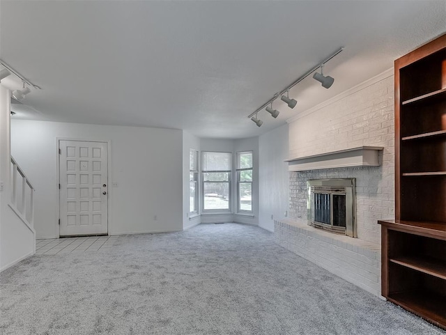 6404 Westway, Oklahoma City, OK 73142 - unfurnished living room with rail lighting, carpet flooring, and a brick fireplace