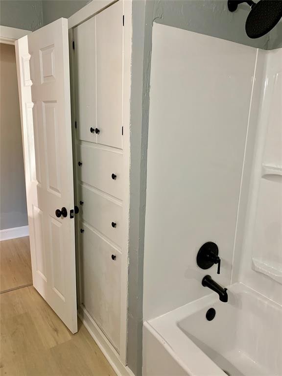 bathroom featuring  shower combination and wood-type flooring