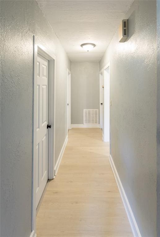 corridor with light hardwood / wood-style flooring