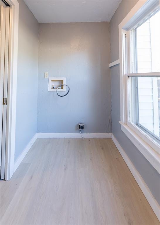 laundry room with washer hookup and light hardwood / wood-style flooring