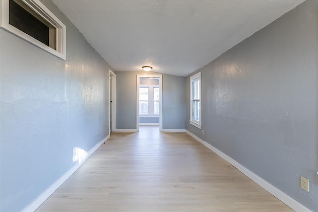 empty room featuring light hardwood / wood-style flooring and vaulted ceiling