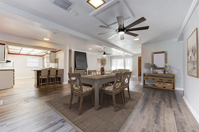 dining space featuring dark hardwood / wood-style flooring, ceiling fan, and ornamental molding