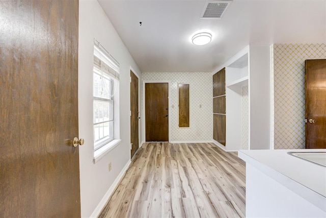 corridor with light hardwood / wood-style floors