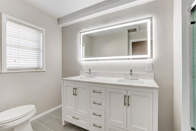 bathroom with tile patterned floors, vanity, toilet, and walk in shower