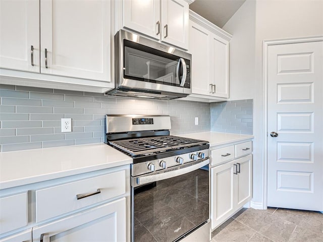 kitchen with backsplash, white cabinetry, stainless steel appliances, and light tile patterned floors