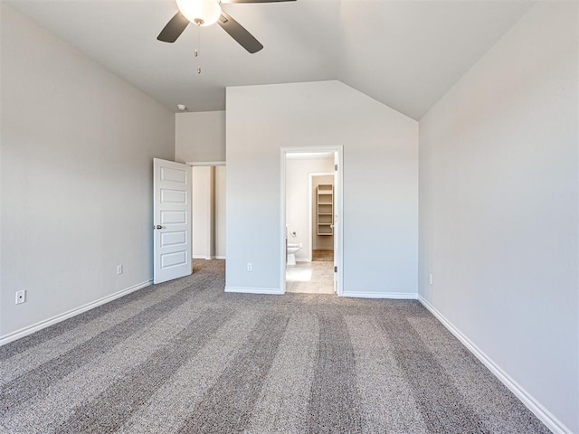 unfurnished bedroom with carpet flooring, a spacious closet, ceiling fan, and lofted ceiling