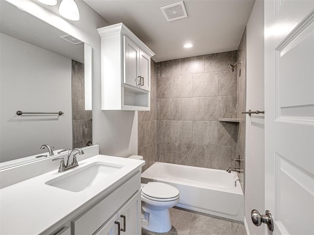 full bathroom with tile patterned flooring, vanity, tiled shower / bath combo, and toilet