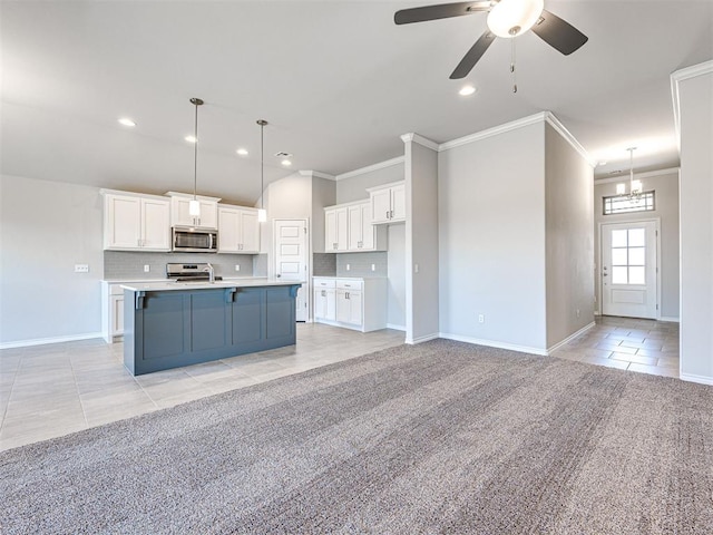 kitchen featuring light carpet, pendant lighting, white cabinets, and stainless steel appliances