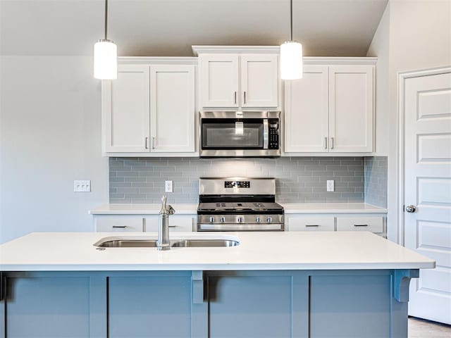 kitchen with white cabinetry, a center island with sink, hanging light fixtures, and appliances with stainless steel finishes