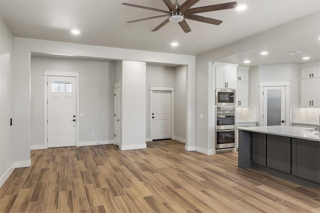 kitchen featuring white cabinets, ceiling fan, and light wood-type flooring