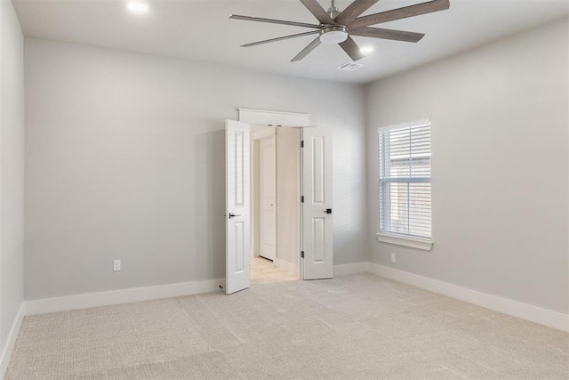 empty room with light colored carpet and ceiling fan