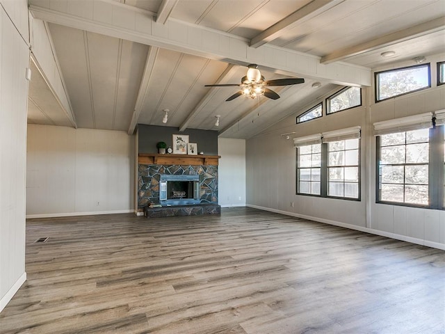 unfurnished living room with vaulted ceiling with beams, ceiling fan, a fireplace, and hardwood / wood-style flooring