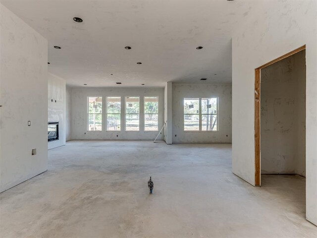 empty room featuring plenty of natural light and a glass covered fireplace