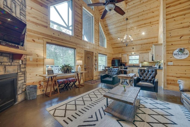 living room featuring wooden ceiling, a stone fireplace, high vaulted ceiling, wooden walls, and ceiling fan with notable chandelier